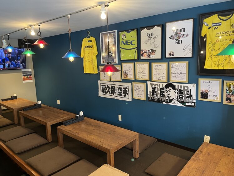 鮮やかなブルーの壁際には、ファミリーに人気の小上がり席。向かいにはカウンターもある。