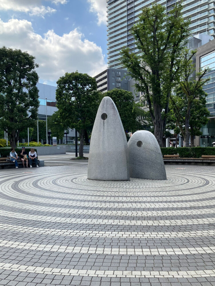 石のモニュメントが中央に置かれた広場は、周囲にベンチもあり待ち合わせしやすい。