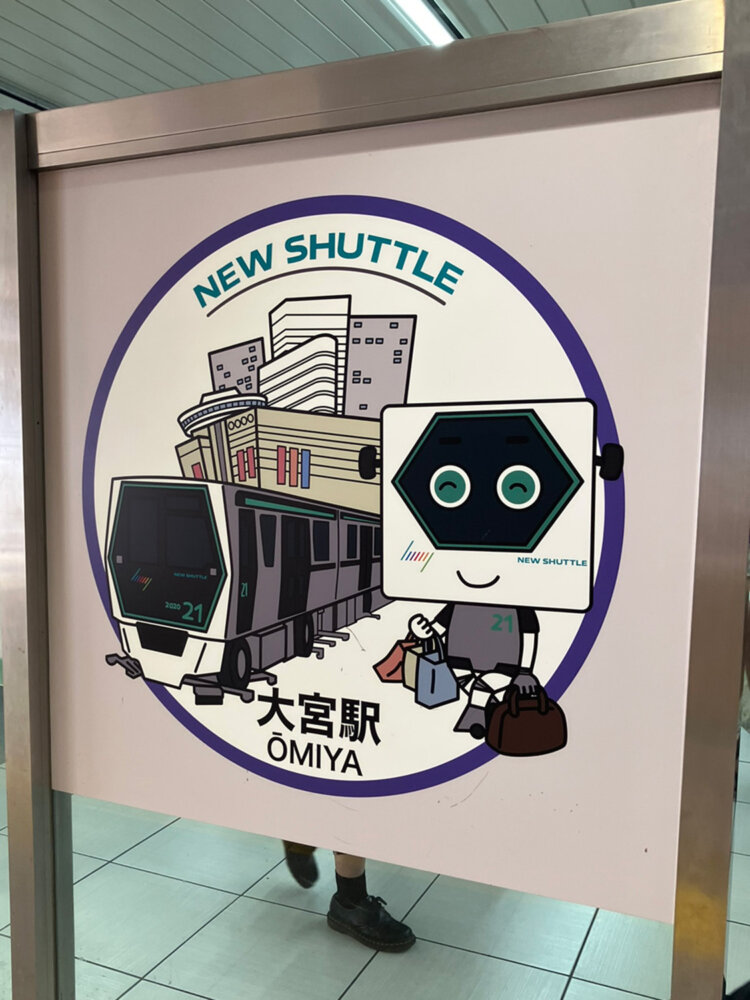 六角形の顔がかわいい「シャトルくん」。イラストパネルはニューシャトルの各駅に設置されているようだ。