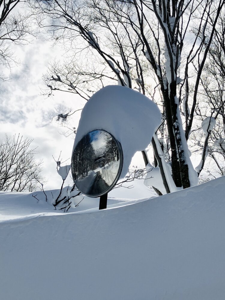 吹雪のあと、雪の帽子を被るカーブミラー。青森・八甲田山にて。