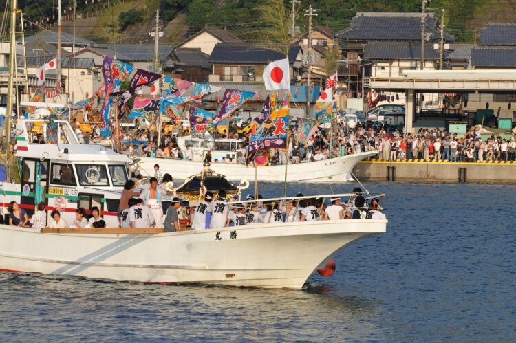 勝浦漁港では多くの観客が見守るなか、神輿を載せた漁船が海を渡る。