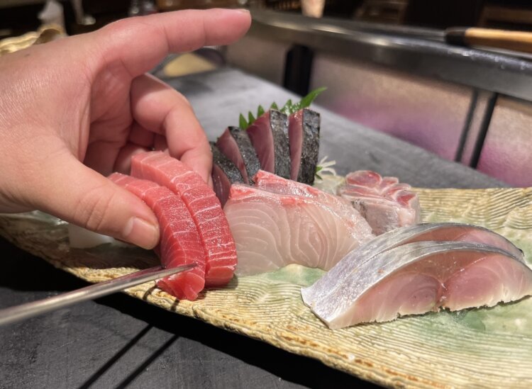 鮮やかな手さばきで盛り付けられていく刺し身。