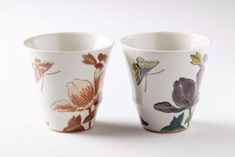 牡丹と蝶の意匠をまとったカップ。金彩が上品な赤絵と深みのある青九谷、各7700円。