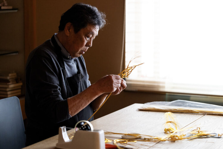 芸術的な結びを生み出す4代目の津田宏さん。力加減や指先のこまやかな動きが仕上がりを左右する。