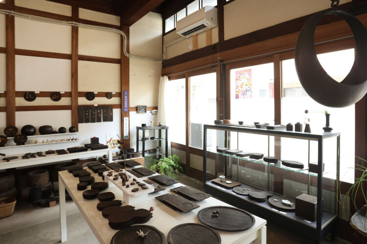 歴史ある町家の店舗に工房が併設。使いやすい小物に愛らしい玩具、伝統的な火鉢などが並ぶ。