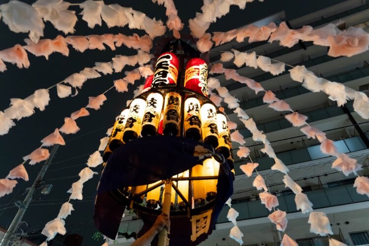 花飾りのついた万灯に明かりが灯り、暗闇によく映えて幻想的。