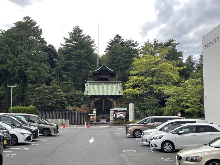 駐車場の向こうに見える不動寺の勅額門。