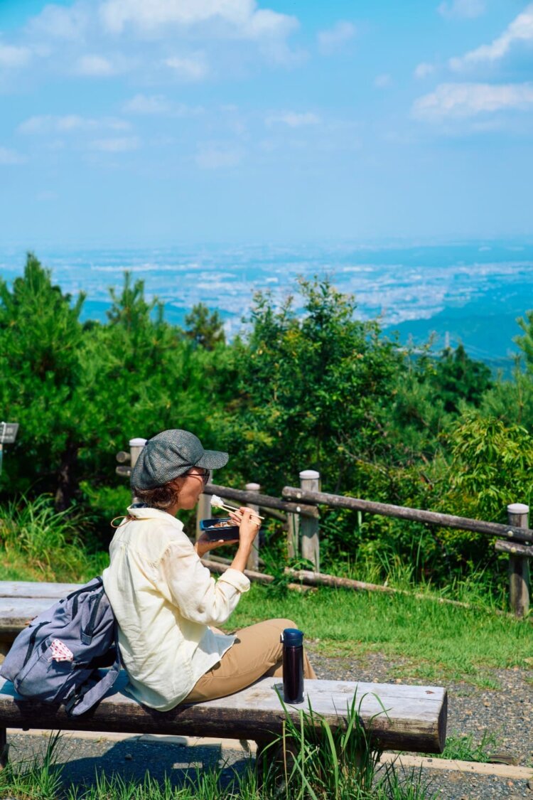 日の出山山頂はベンチが並び、お弁当を広げるのにうってつけ。関東平野をおかずにお弁当タイム。